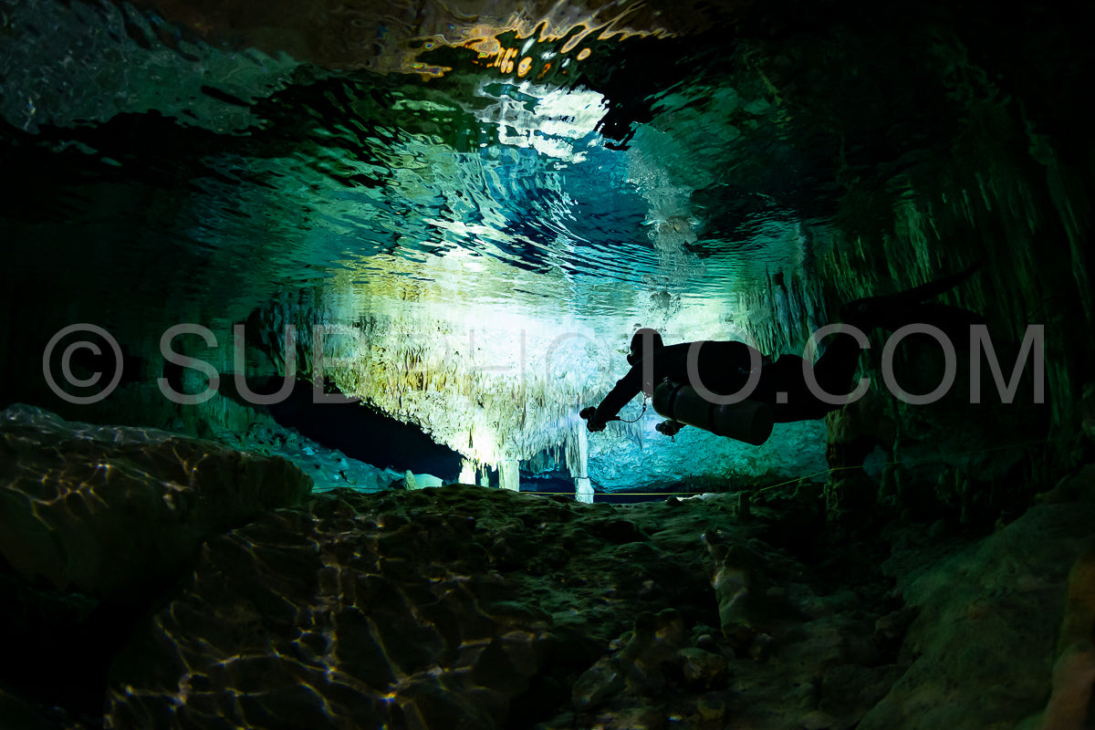 cave diver instructor leading a group of divers in a mexican cenote underwater