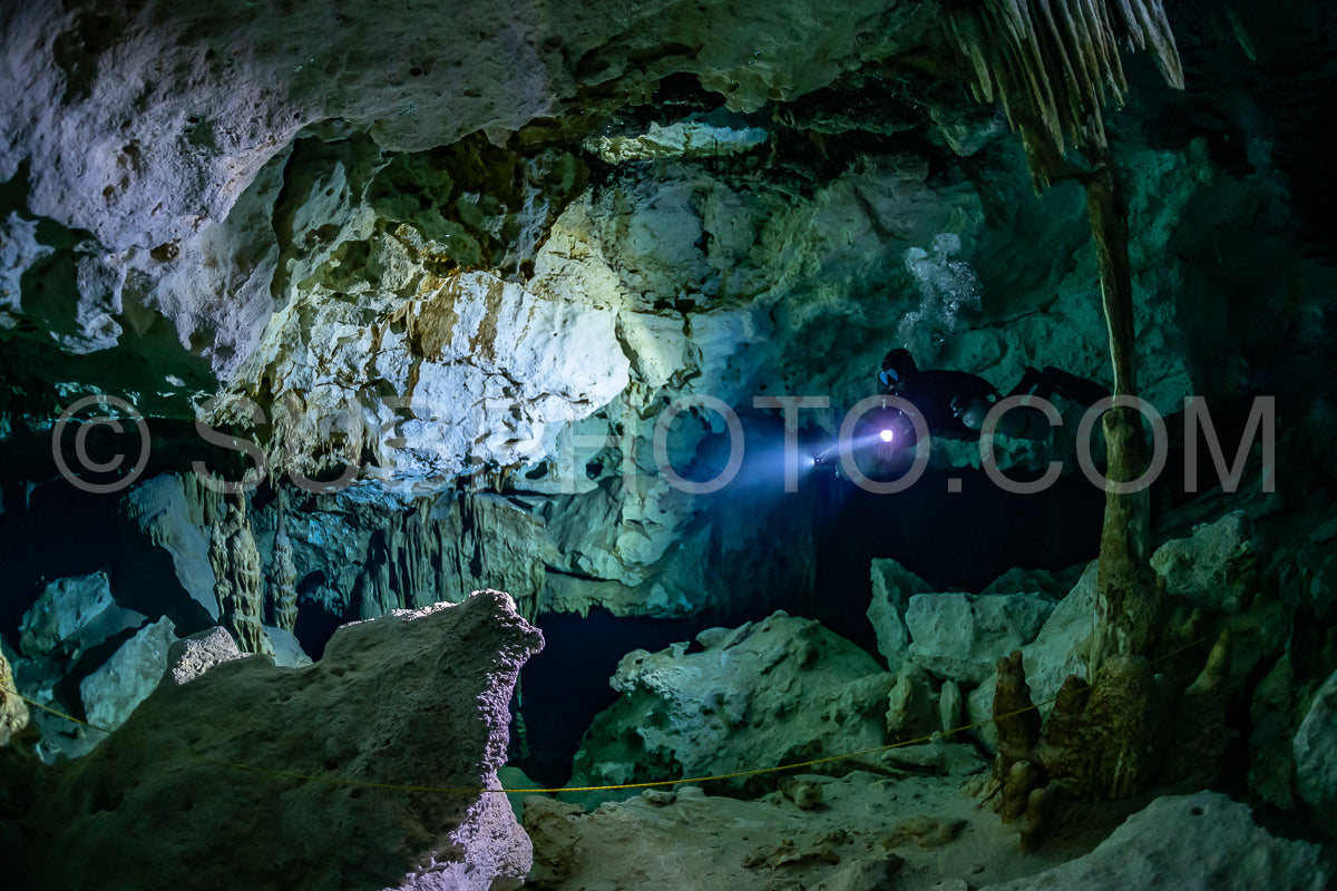 Photo de instructeur de plongée spéléo dirigeant un groupe de plongeurs dans un cenote mexicain sous l'eau