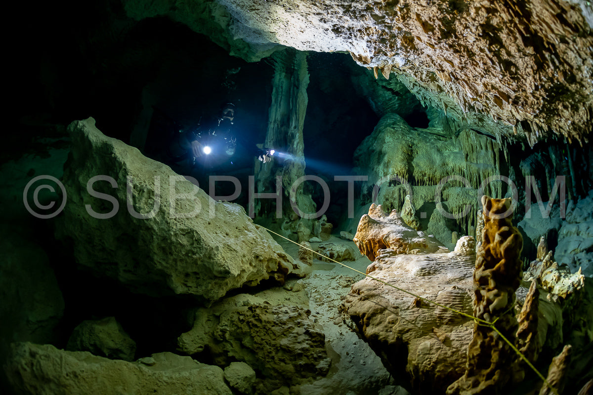 cave diver instructor leading a group of divers in a mexican cenote underwater