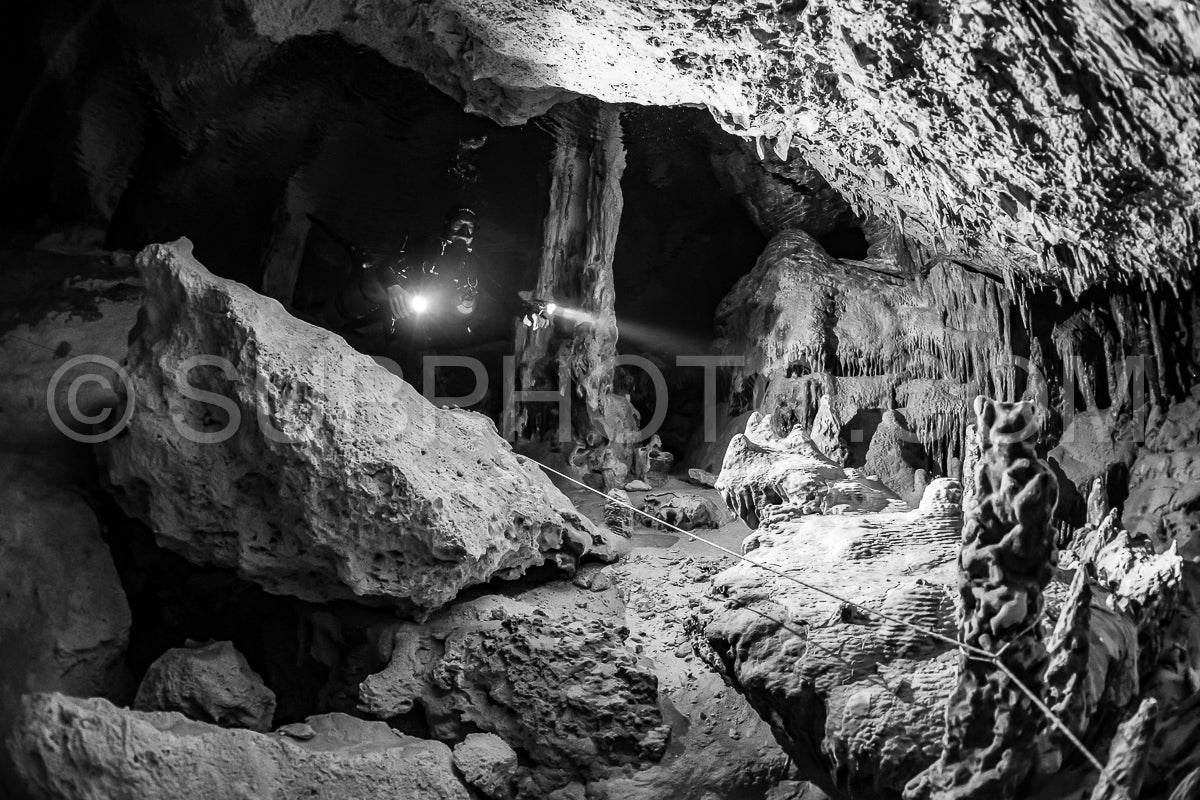 Photo de instructeur de plongée spéléo dirigeant un groupe de plongeurs dans un cenote mexicain sous l'eau