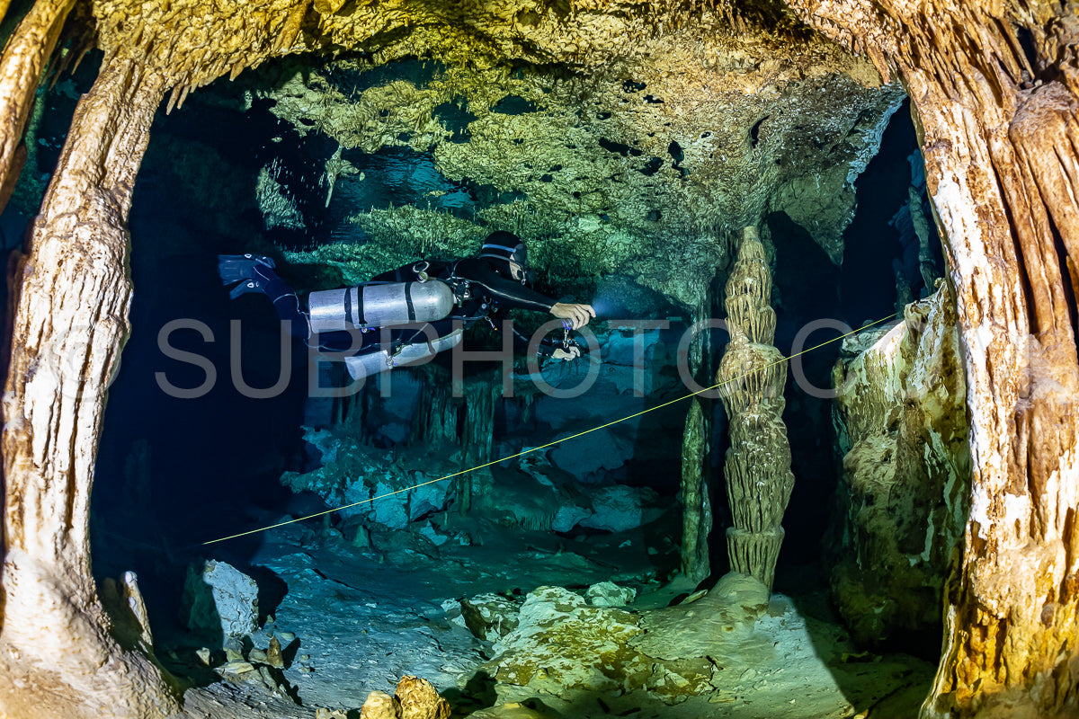 cave diver instructor leading a group of divers in a mexican cenote underwater
