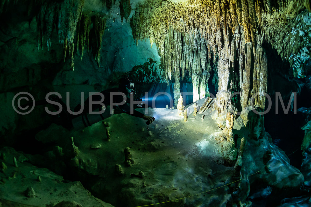 cave diver instructor leading a group of divers in a mexican cenote underwater
