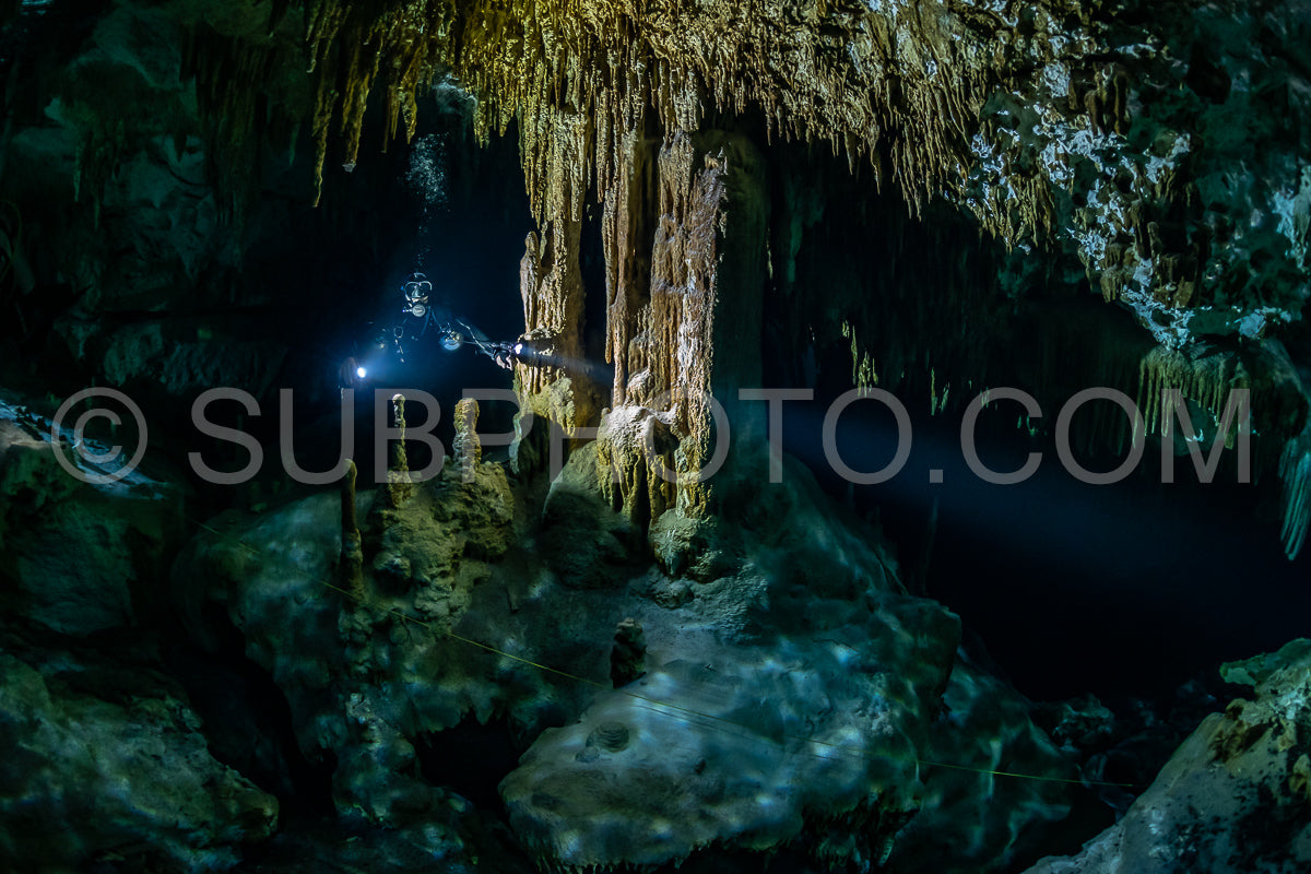 cave diver instructor leading a group of divers in a mexican cenote underwater
