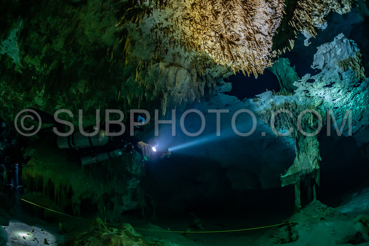 Photo de instructeur de plongée spéléo dirigeant un groupe de plongeurs dans un cenote mexicain sous l'eau