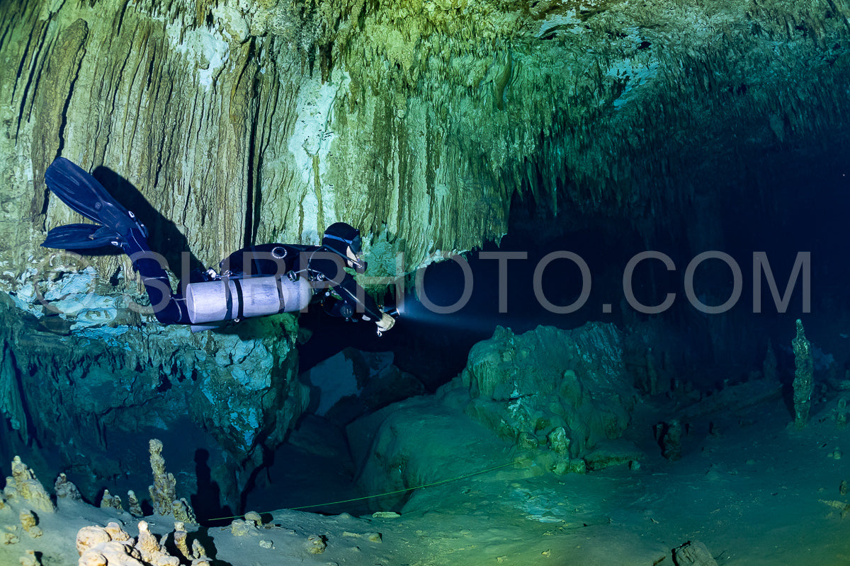 cave diver instructor leading a group of divers in a mexican cenote underwater