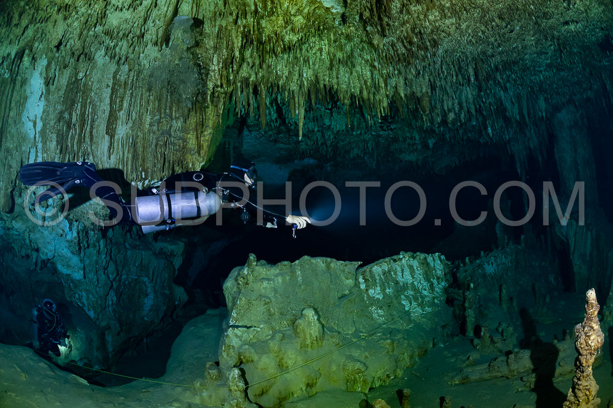 cave diver instructor leading a group of divers in a mexican cenote underwater