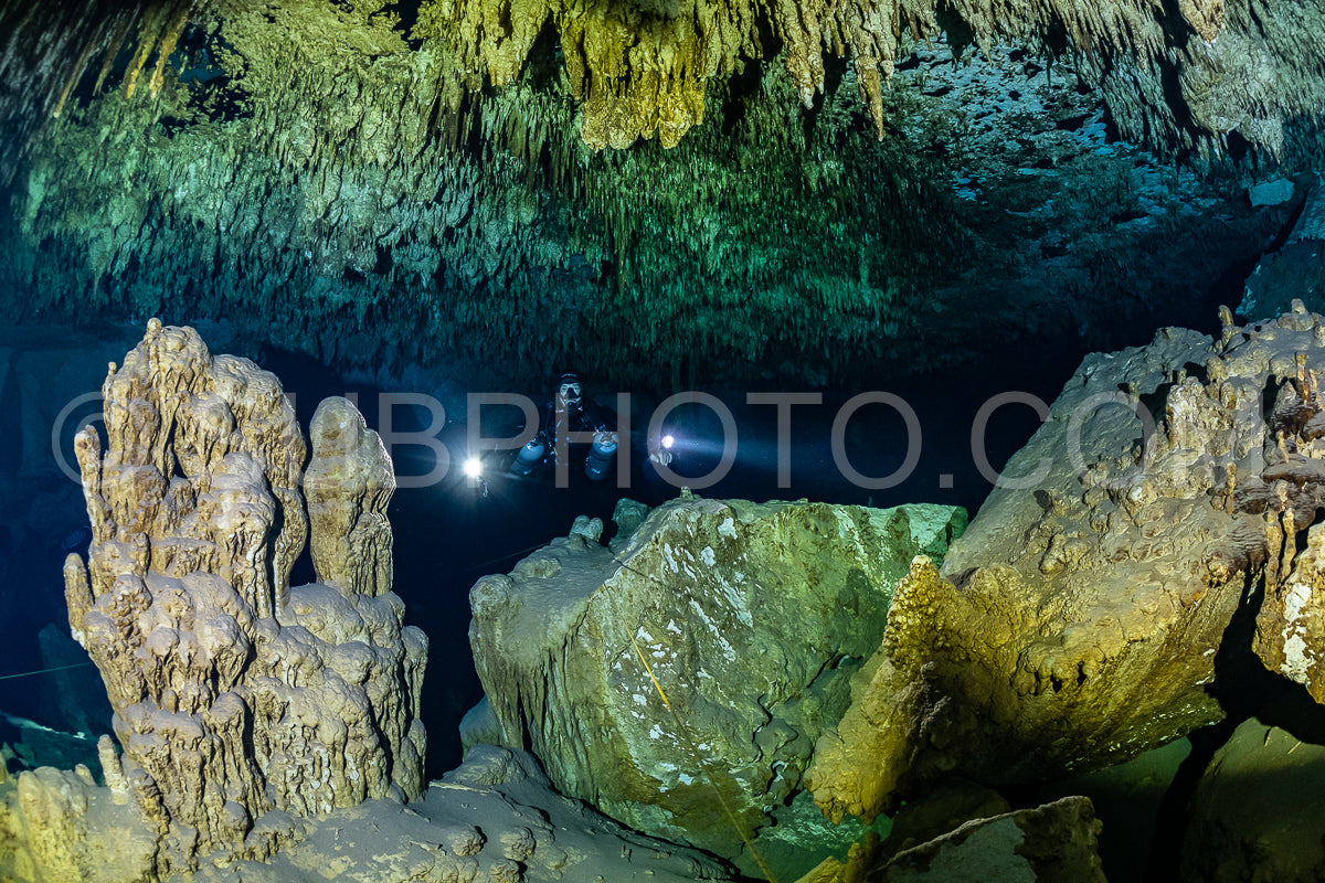 cave diver instructor leading a group of divers in a mexican cenote underwater