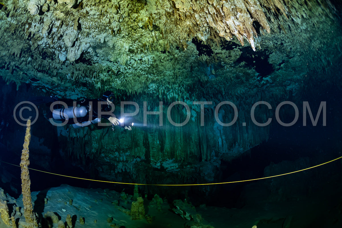 cave diver instructor leading a group of divers in a mexican cenote underwater