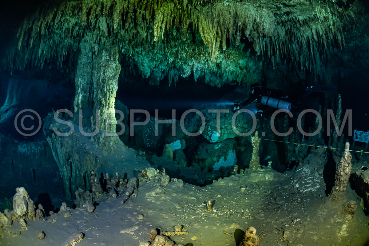 cave diver instructor leading a group of divers in a mexican cenote underwater