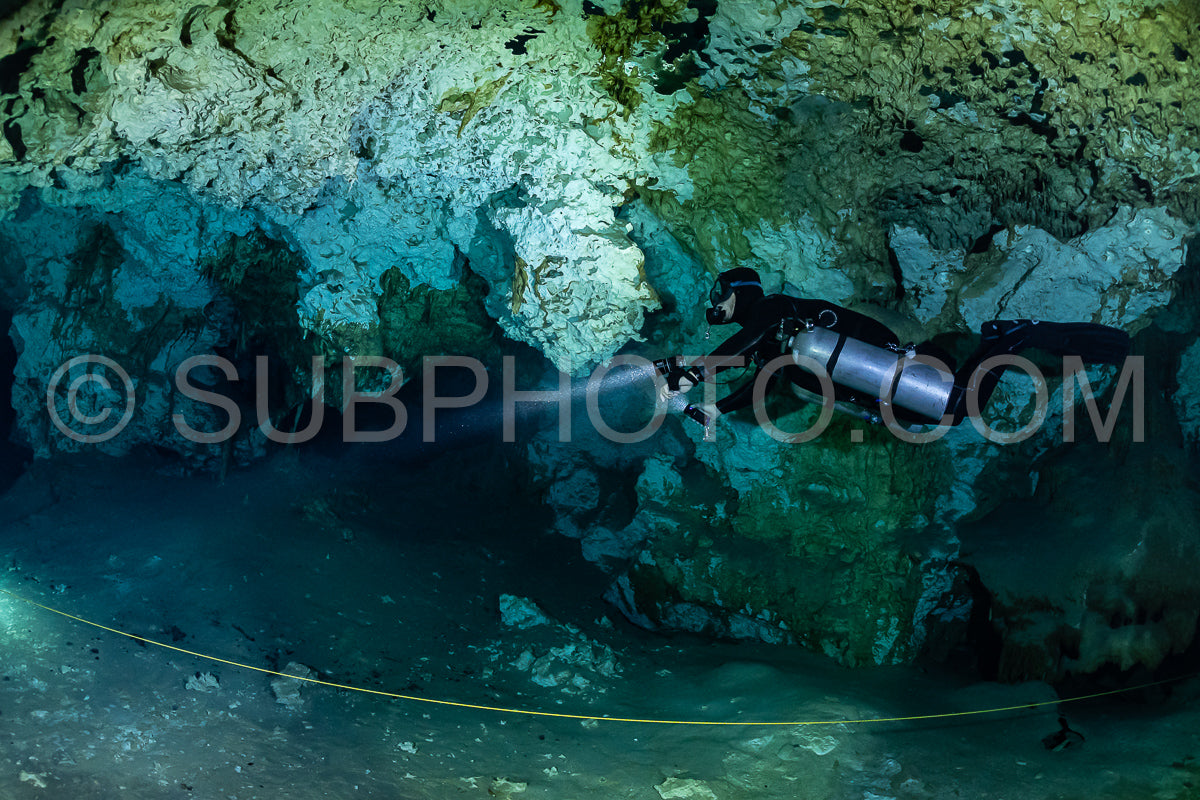 cave diver instructor leading a group of divers in a mexican cenote underwater