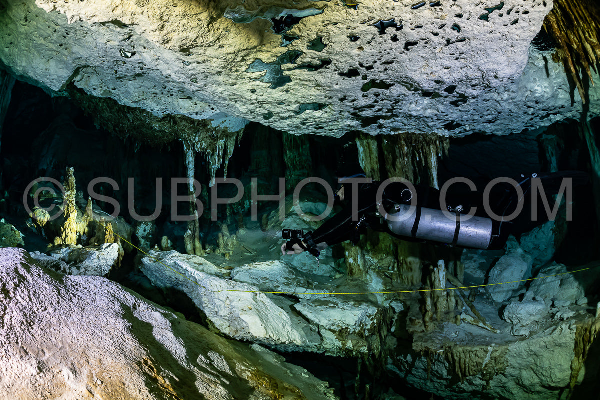Photo de instructeur de plongée spéléo dirigeant un groupe de plongeurs dans un cenote mexicain sous l'eau