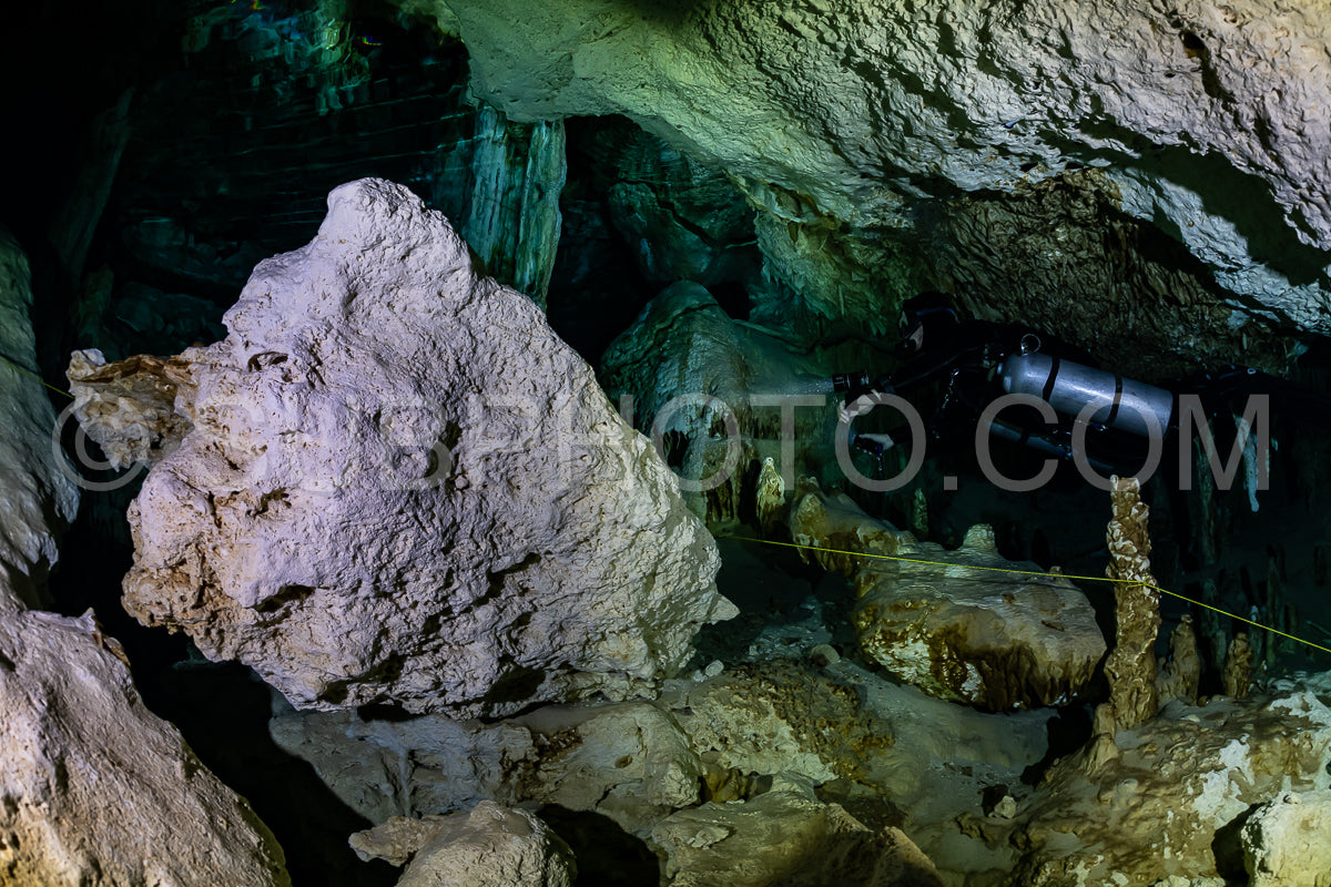 Photo de instructeur de plongée spéléo dirigeant un groupe de plongeurs dans un cenote mexicain sous l'eau