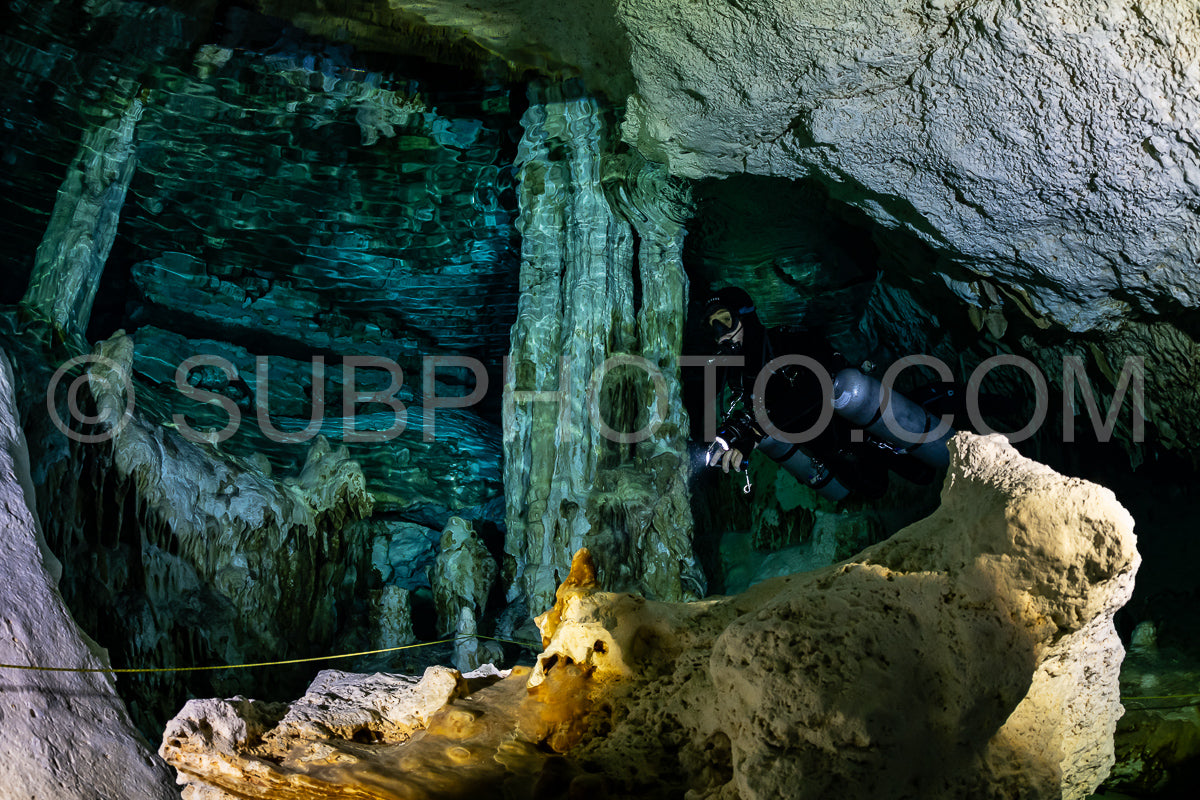 cave diver instructor leading a group of divers in a mexican cenote underwater