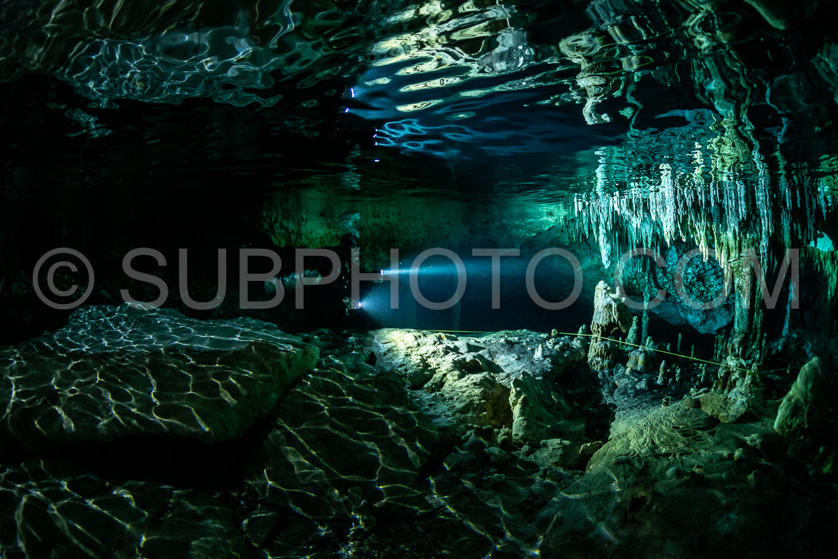 cave diver instructor leading a group of divers in a mexican cenote underwater