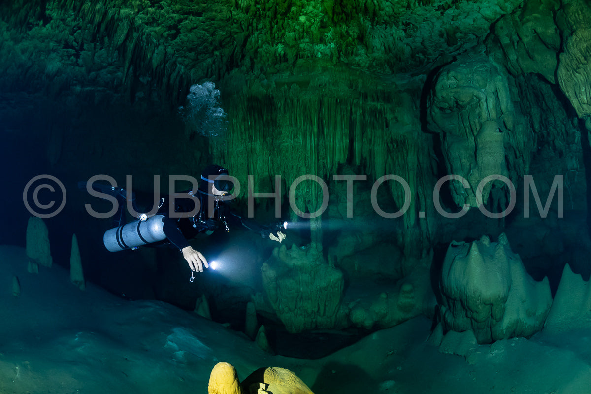 cave diver instructor leading a group of divers in a mexican cenote underwater