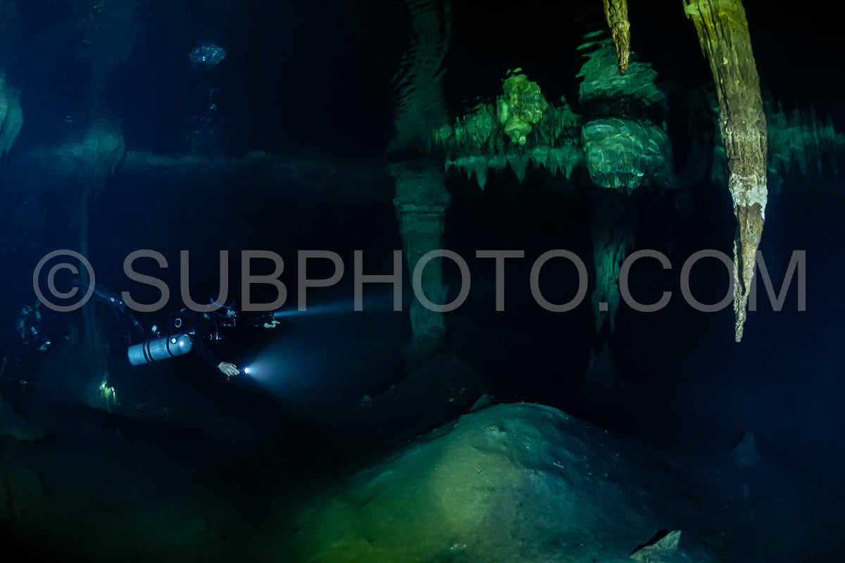 cave diver instructor leading a group of divers in a mexican cenote underwater
