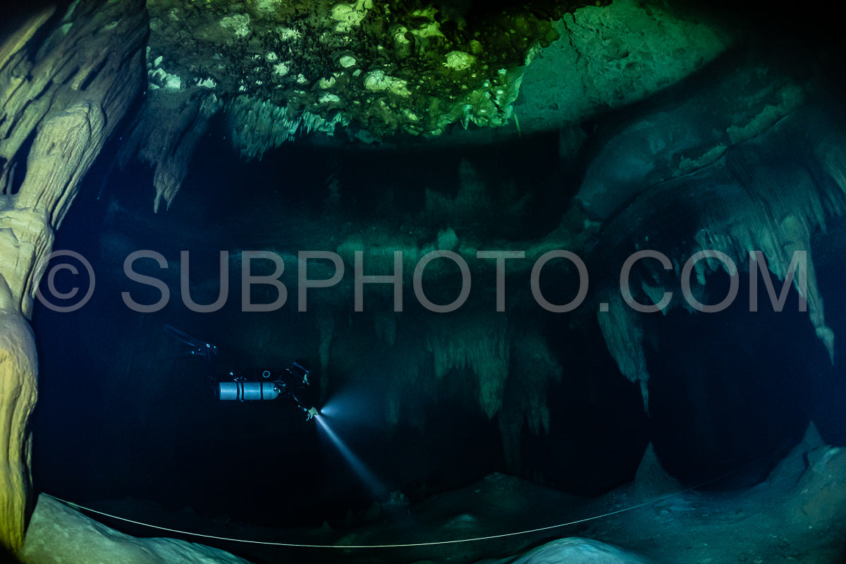 cave diver instructor leading a group of divers in a mexican cenote underwater