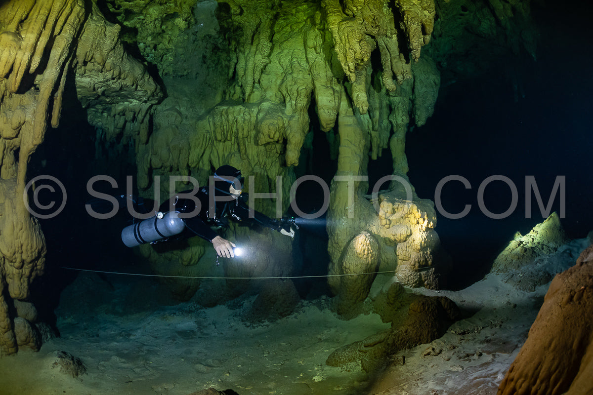 cave diver instructor leading a group of divers in a mexican cenote underwater