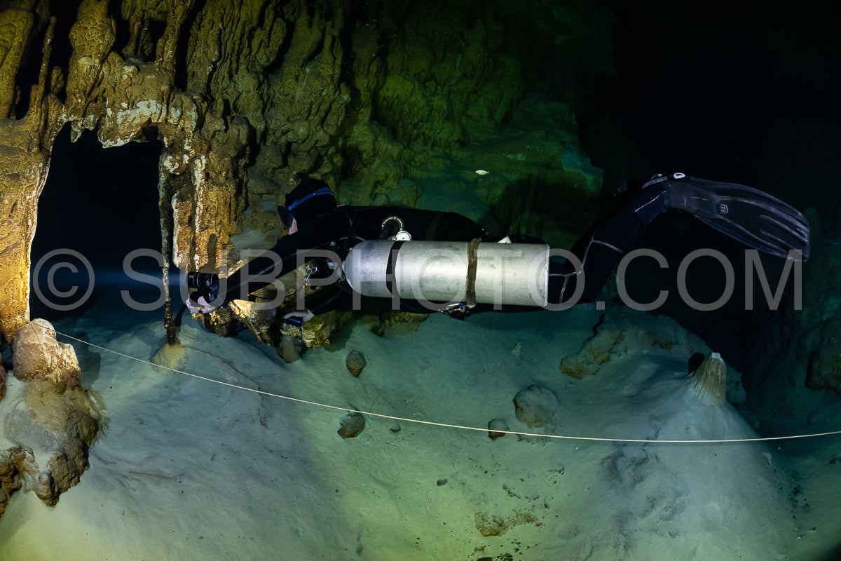cave diver instructor leading a group of divers in a mexican cenote underwater
