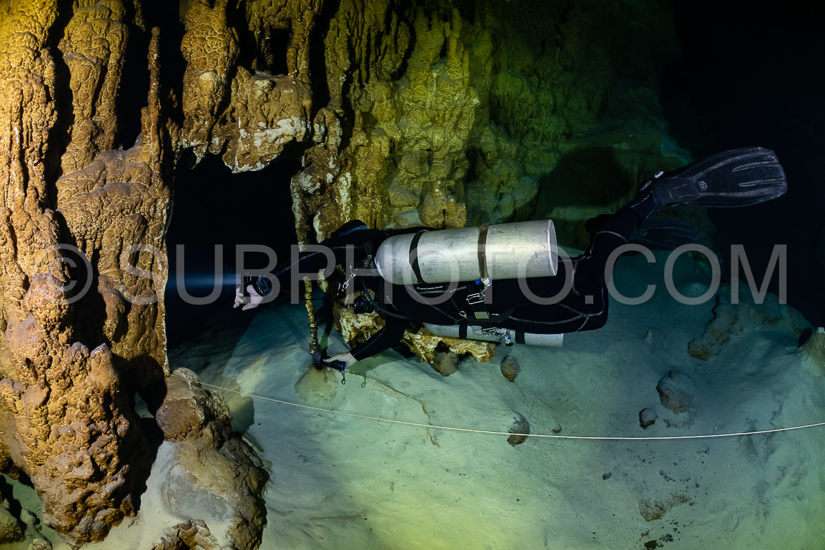 Photo de instructeur de plongée spéléo dirigeant un groupe de plongeurs dans un cenote mexicain sous l'eau
