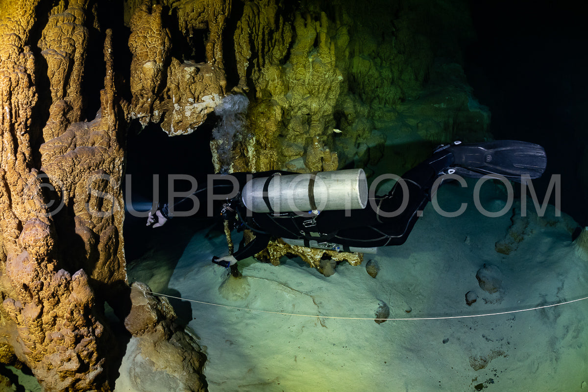 cave diver instructor leading a group of divers in a mexican cenote underwater