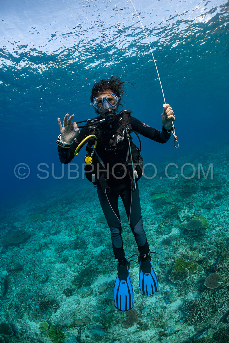 woman diver using a surface marking tube or smb buoy