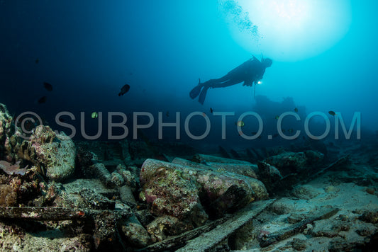scuba diver over the wooden wreck of a diving boat with tanks in Maratua