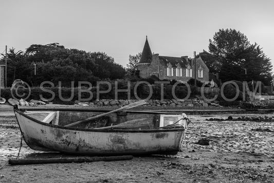 Small boat gounded in low tide in from of an manor