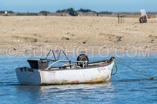Small withe boat at low tide