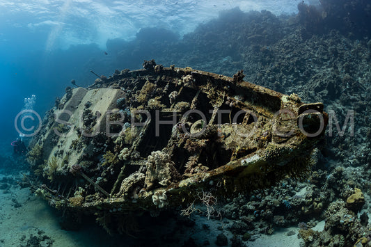 divers visiting an underwater wreck of a metal sailboat on a reef in the Rea Sea- Egypt