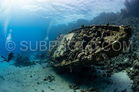 divers visiting an underwater wreck of a metal sailboat on a reef in the Rea Sea- Egypt