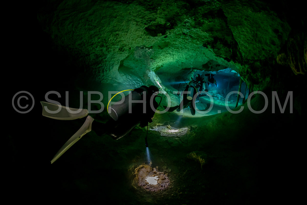 cave diver instructor leading a group of divers in a mexican cenote underwater