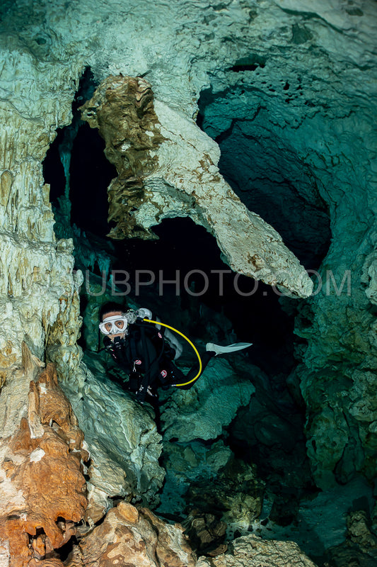cave diver instructor leading a group of divers in a mexican cenote underwater