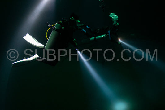 cave diver instructor leading a group of divers in a mexican cenote underwater