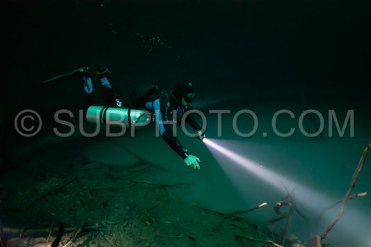 cave diver instructor leading a group of divers in a mexican cenote underwater