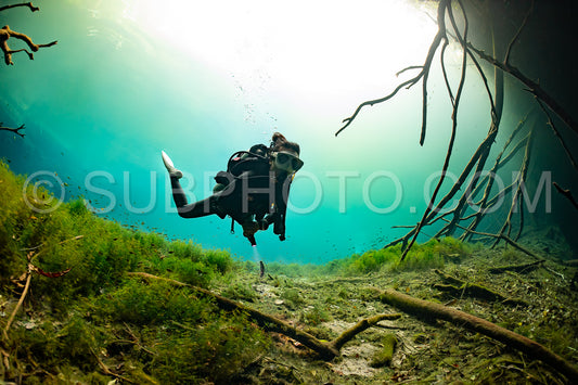 cave diver instructor leading a group of divers in a mexican cenote underwater