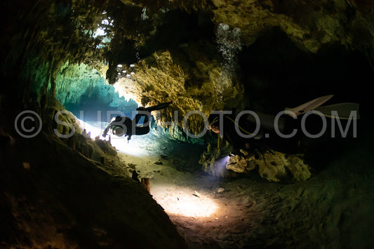 cave diver instructor leading a group of divers in a mexican cenote underwater