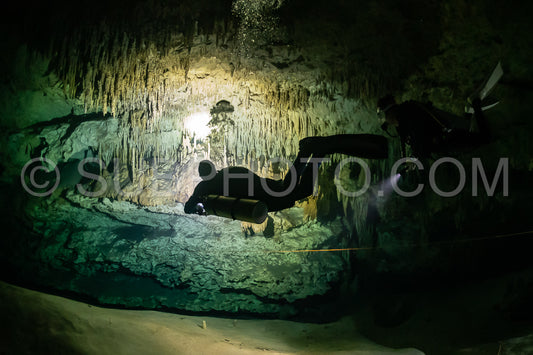 cave diver instructor leading a group of divers in a mexican cenote underwater