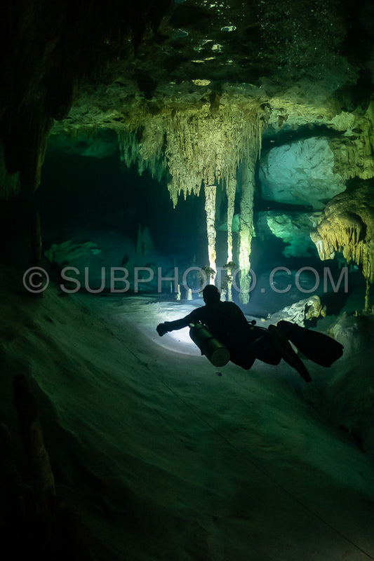 cave diver instructor leading a group of divers in a mexican cenote underwater