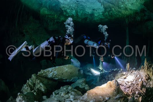 cave diver instructor leading a group of divers in a mexican cenote underwater
