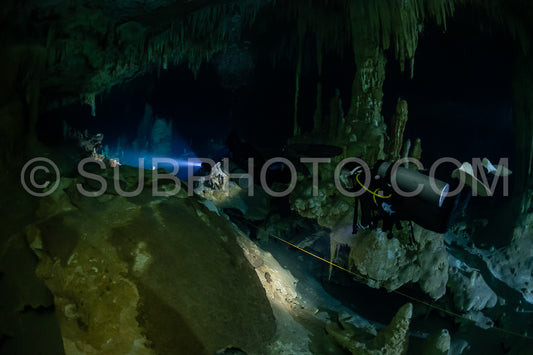cave diver instructor leading a group of divers in a mexican cenote underwater