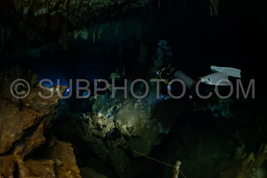 cave diver instructor leading a group of divers in a mexican cenote underwater