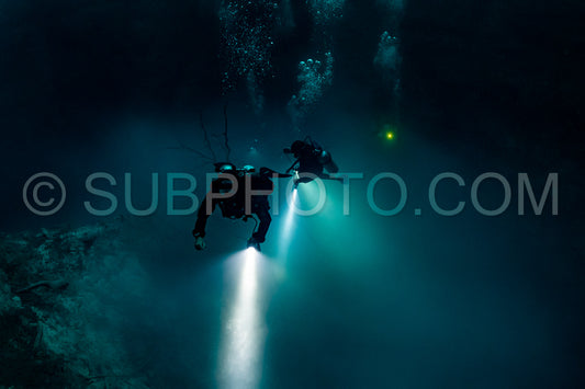 cave diver instructor leading a group of divers in a mexican cenote underwater
