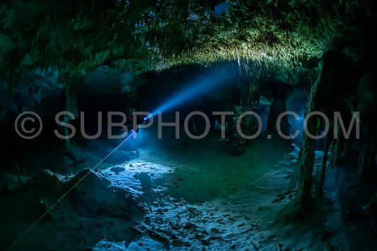 cave diver instructor leading a group of divers in a mexican cenote underwater