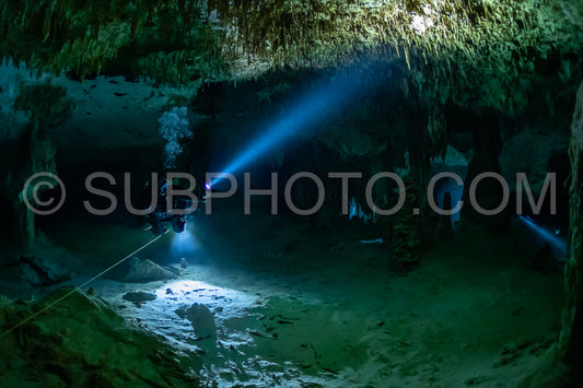 cave diver instructor leading a group of divers in a mexican cenote underwater
