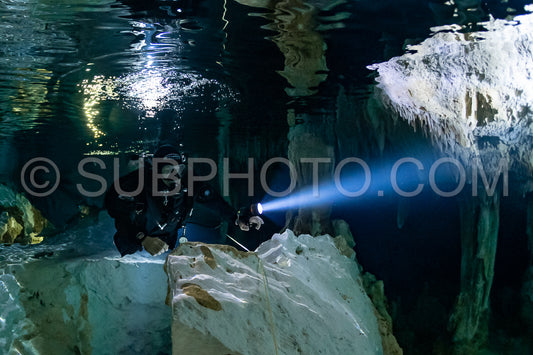 cave diver instructor leading a group of divers in a mexican cenote underwater