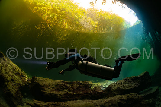 cave diver instructor leading a group of divers in a mexican cenote underwater