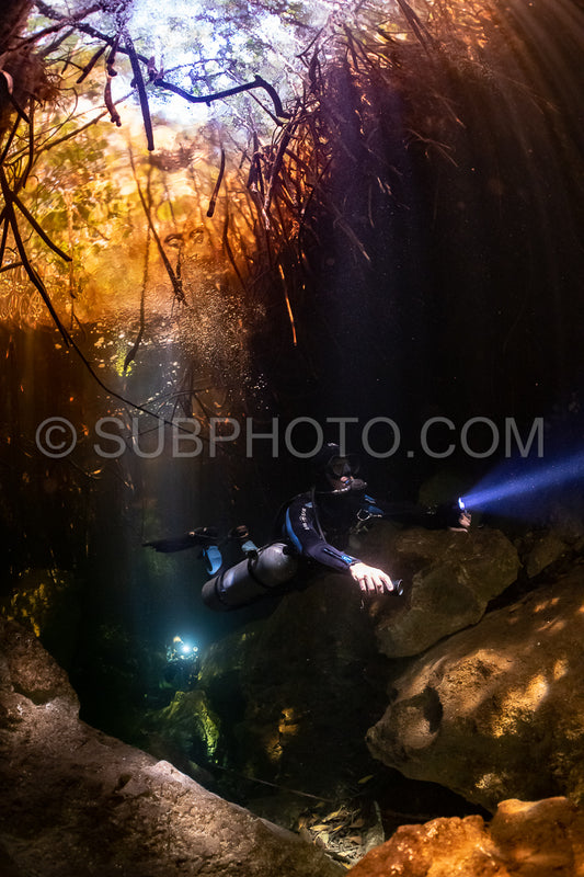 cave diver instructor leading a group of divers in a mexican cenote underwater
