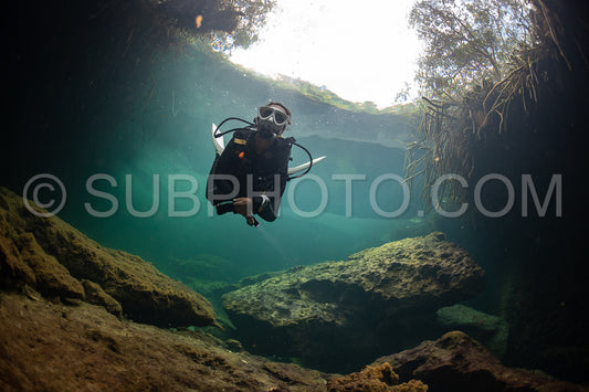 cave diver instructor leading a group of divers in a mexican cenote underwater