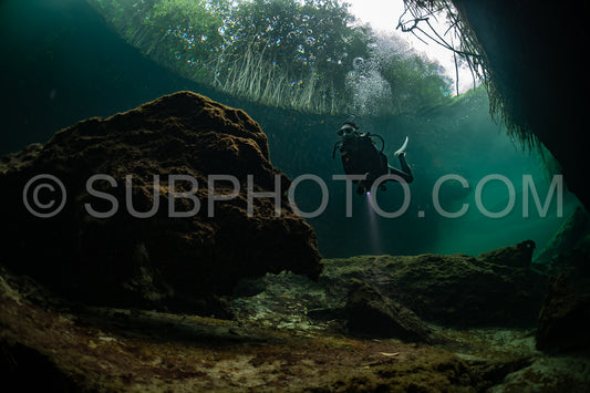 cave diver instructor leading a group of divers in a mexican cenote underwater